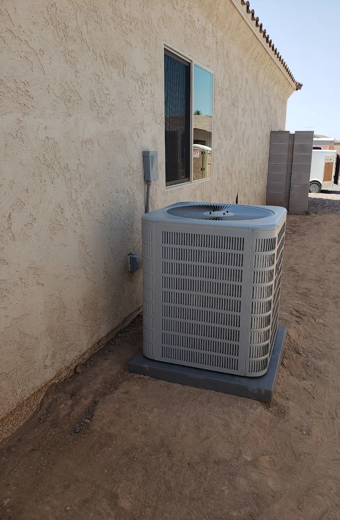 Residential outdoor air conditioning condenser beside a home